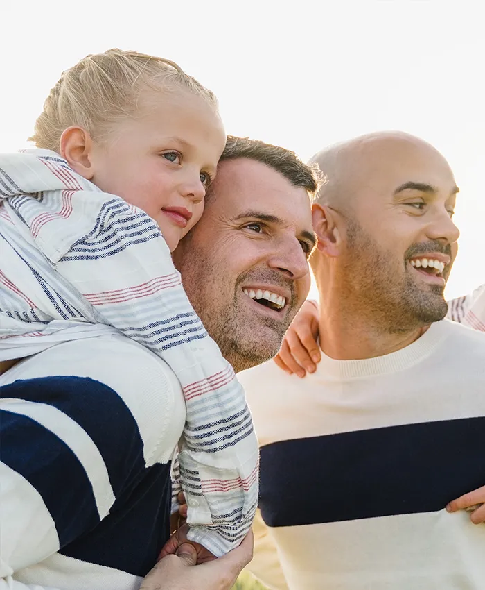 Daughter and her two fathers sharing a day out and smiling